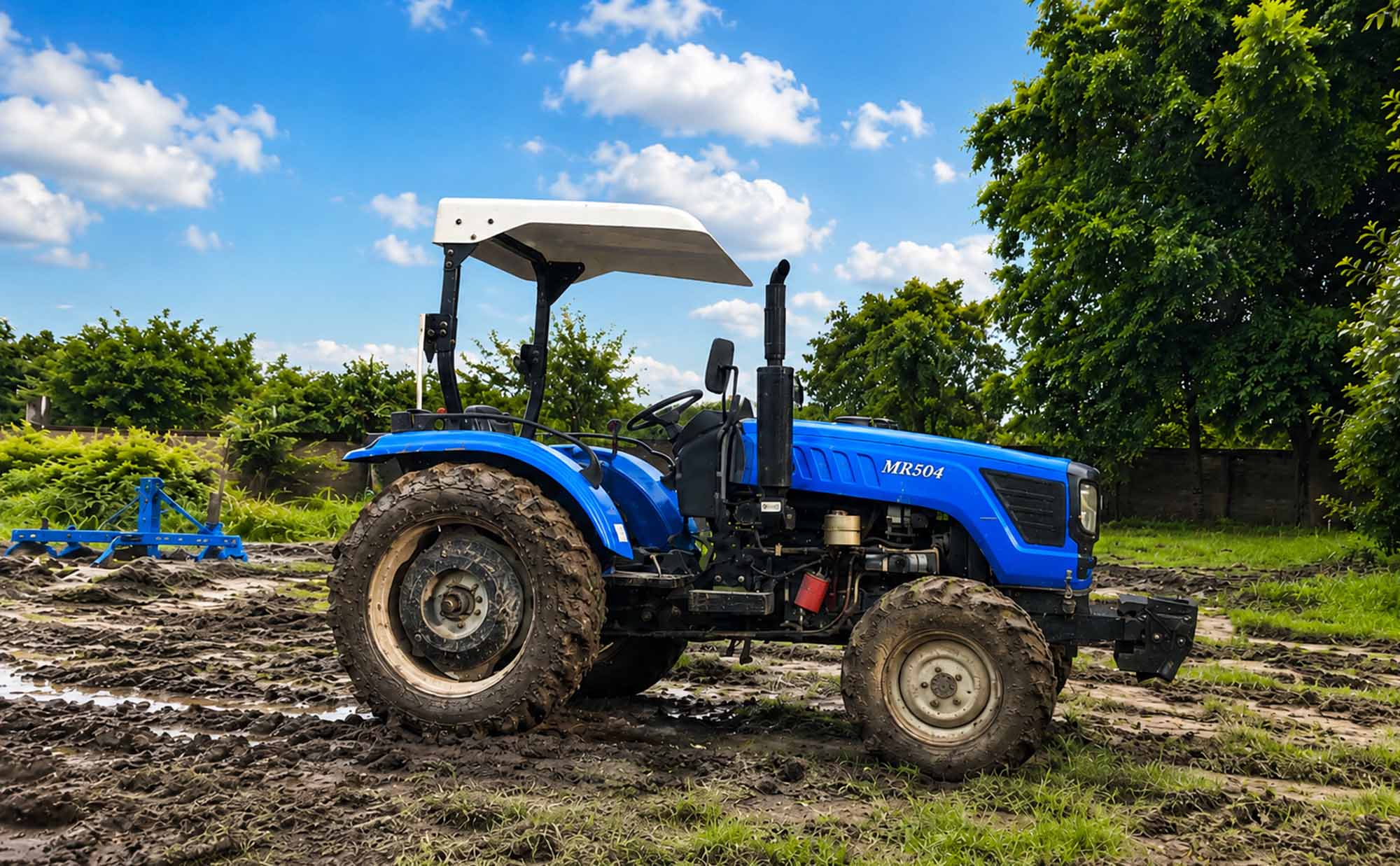 Tractor de trabajo en pleno campo paraguayo, con las ruedas embarradas y palmeras de fondo
